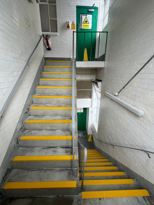 GRP anti-slip stair nosing installed on industrial metal staircase with yellow safety edge