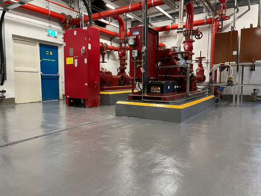 Anti-slip epoxy floor coating installed in a boiler room and pump house with yellow safety edges on equipment plinths in Hazel Grove
