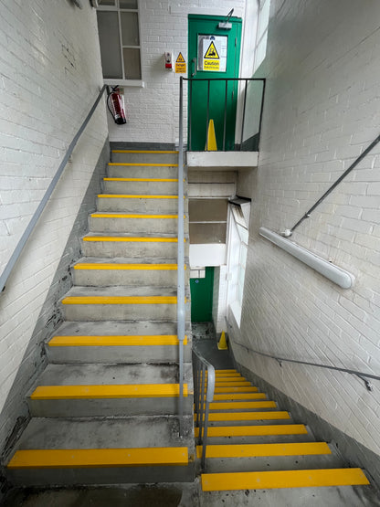 Underground parking garage with Concrete staircase with yellow GRP anti-Slip stair nosings.