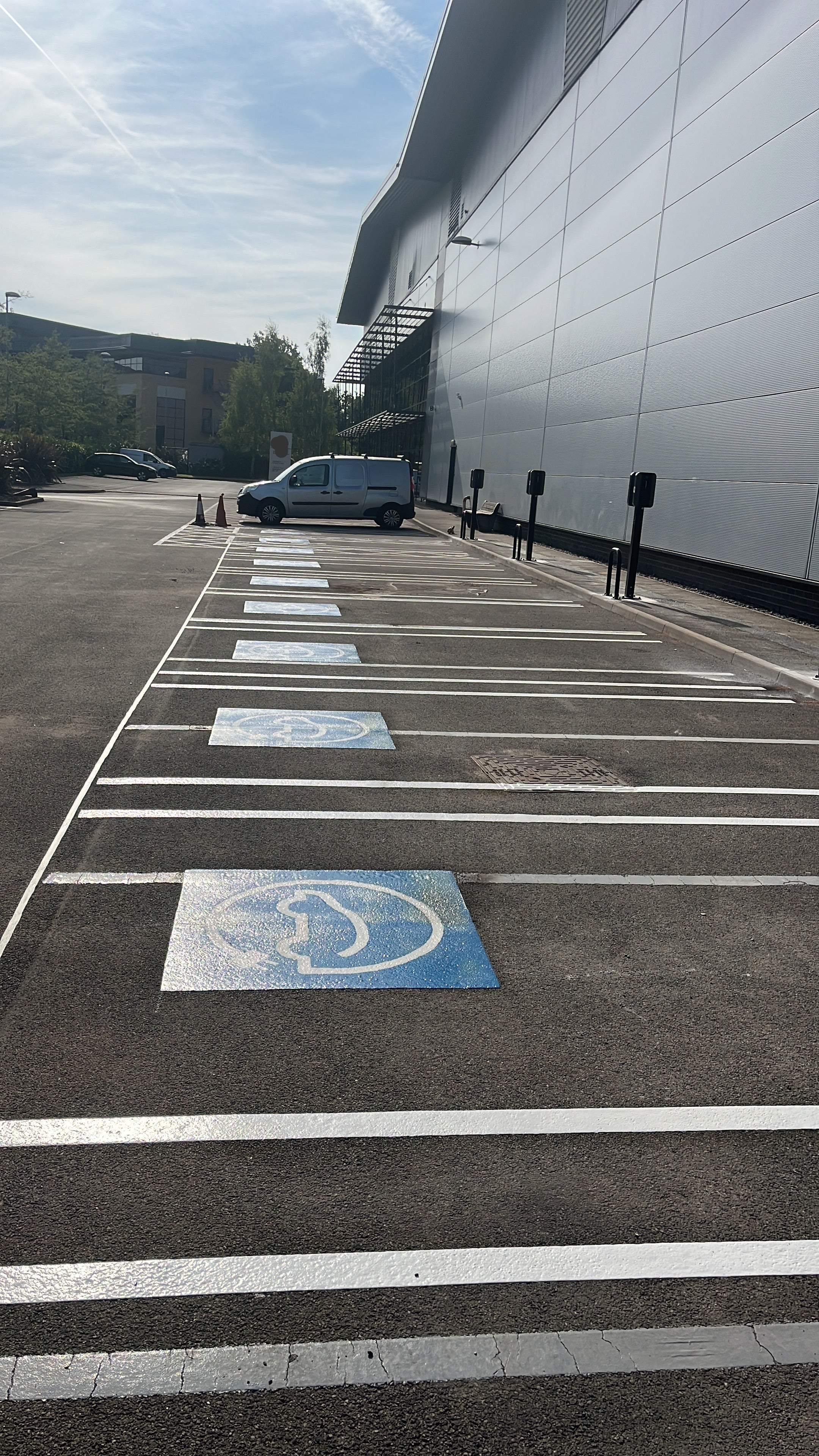 Electric vehicle parking bay with blue and white symbols