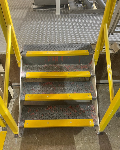 Metal staircase with yellow handrails and yellow GRP anti-slip stair nosings