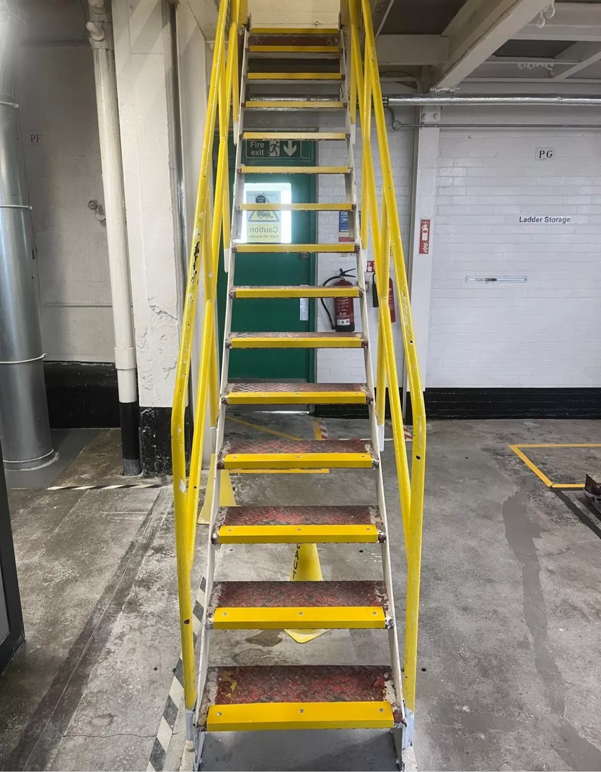 Yellow metal ladder inside a building with yellow GRP stair nosings