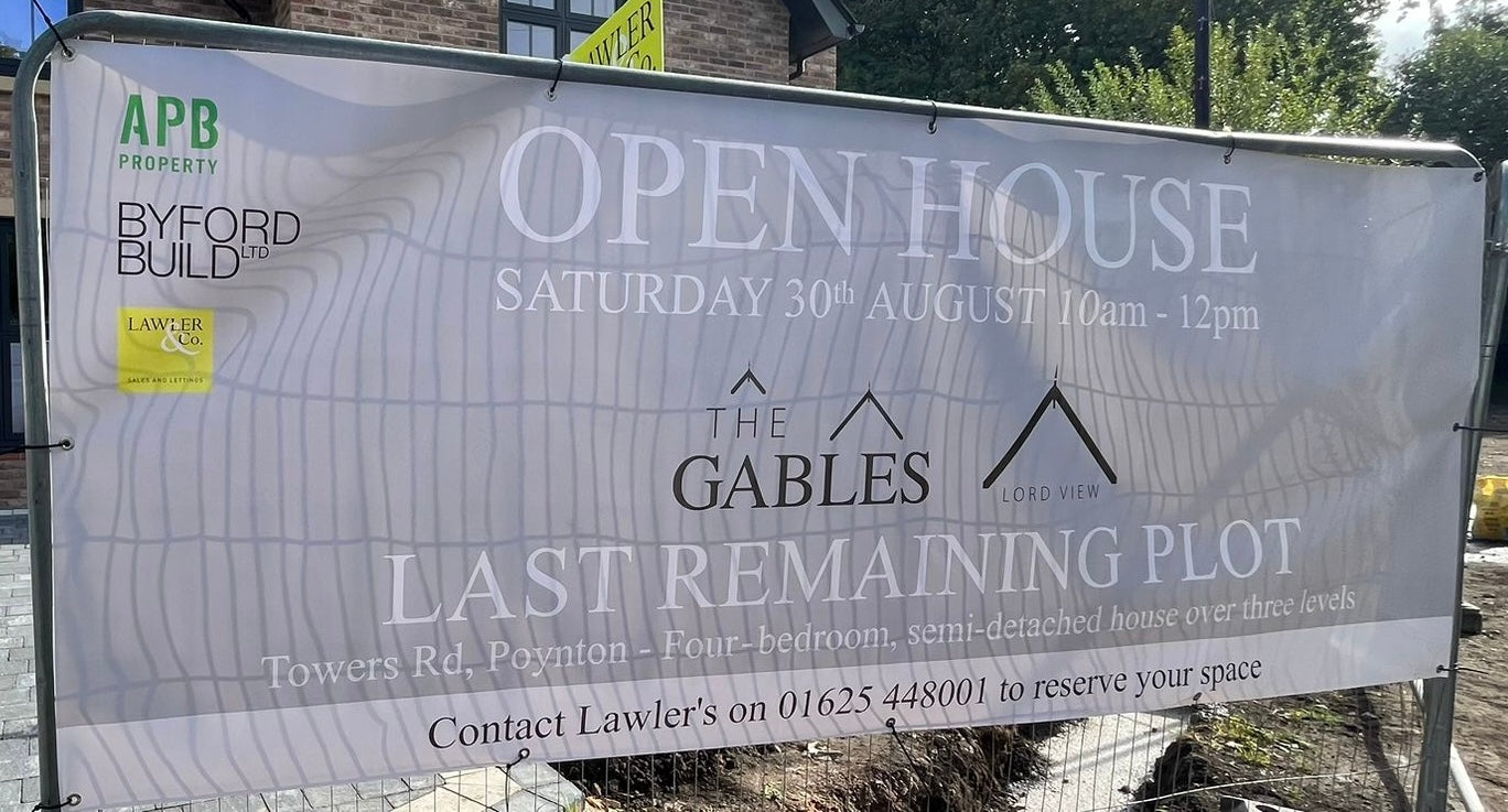 Open house banner for 'The Gables' with contact information on a construction site.