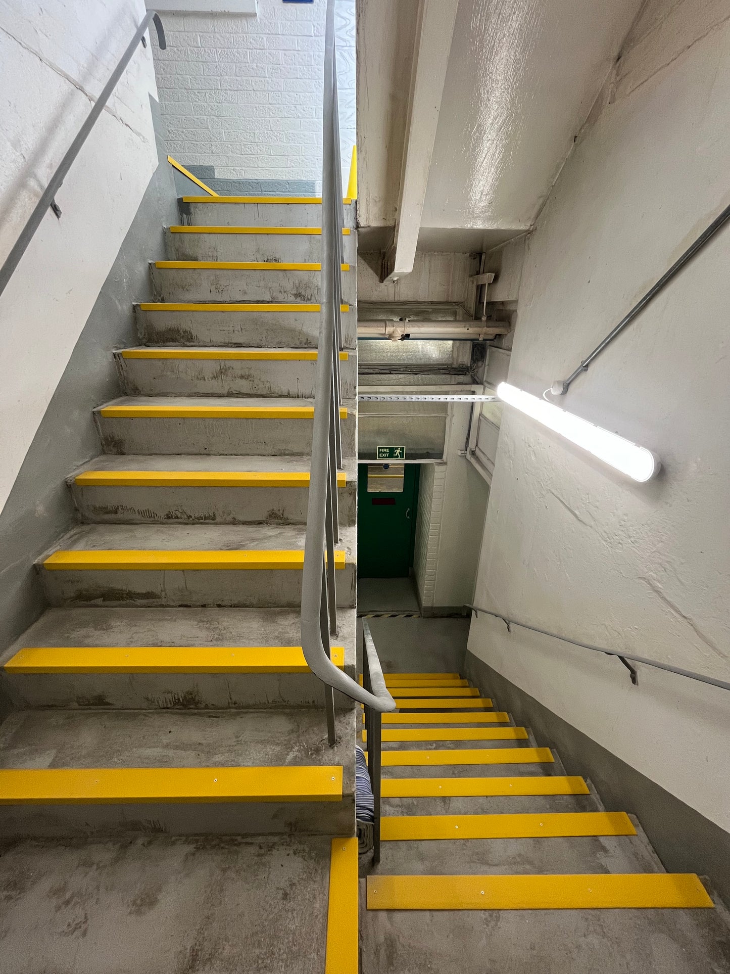 Concrete staircase with yellow GRP anti-Slip stair nosings in an industrial setting